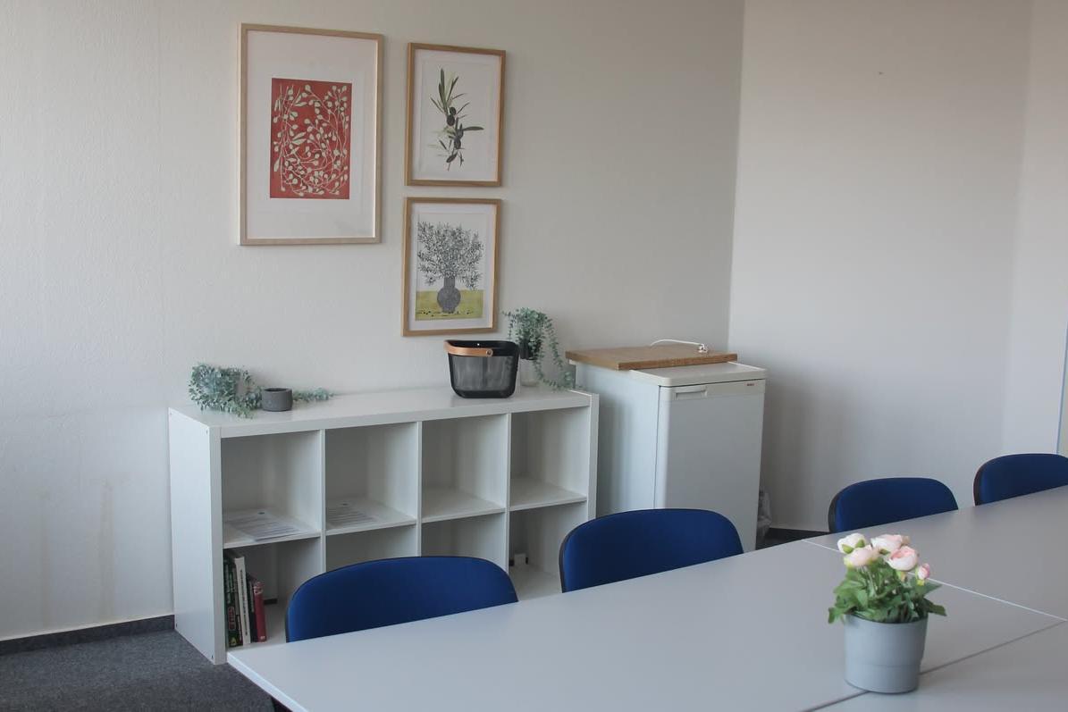 Aufenthaltsraum mit Regal und Bildern an der Wand