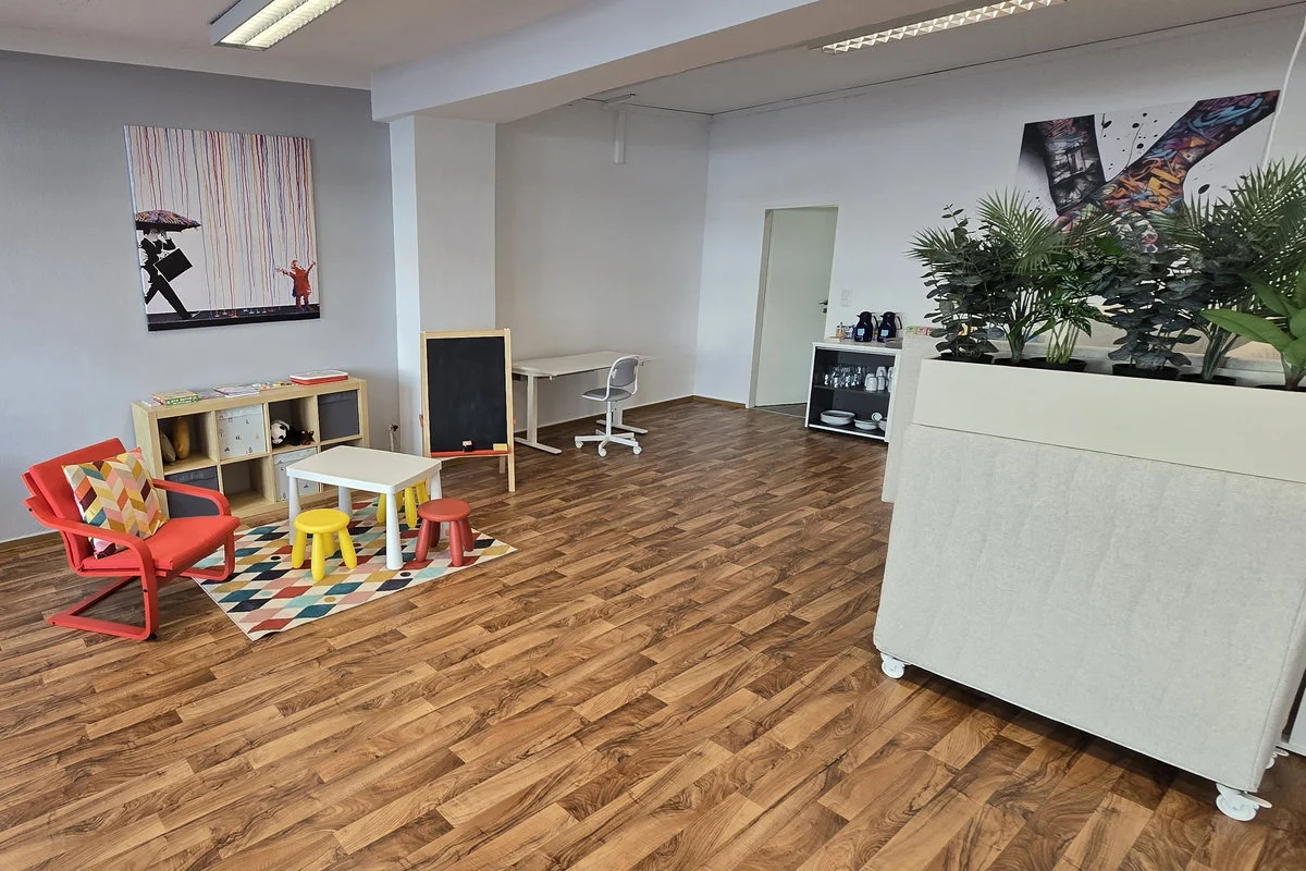 Links eine Spielecke für Kinder und rechts der Blick auf die PC-Arbeitsplätze