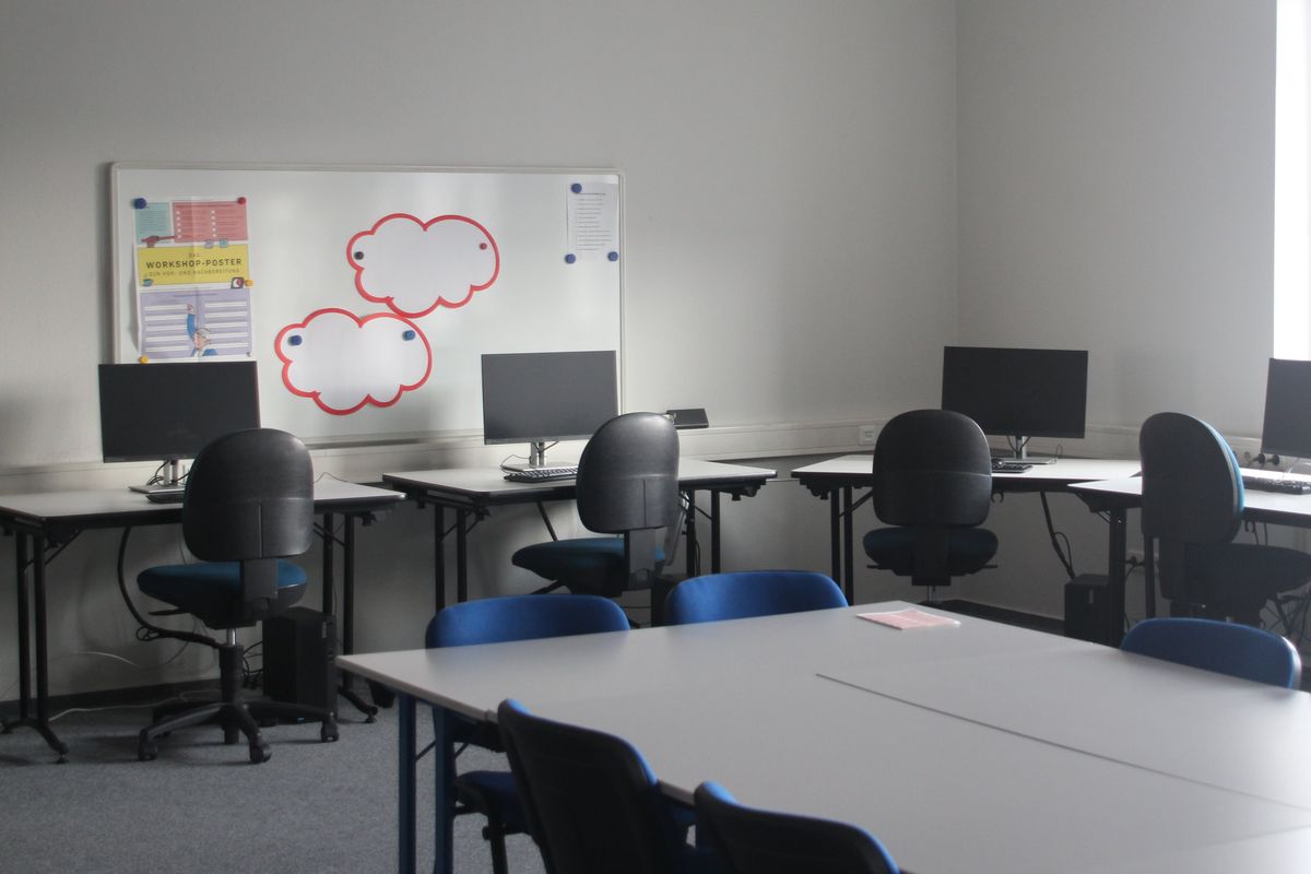 Schulungsraum mit Gruppentisch und EDV-Arbeitsplätzen